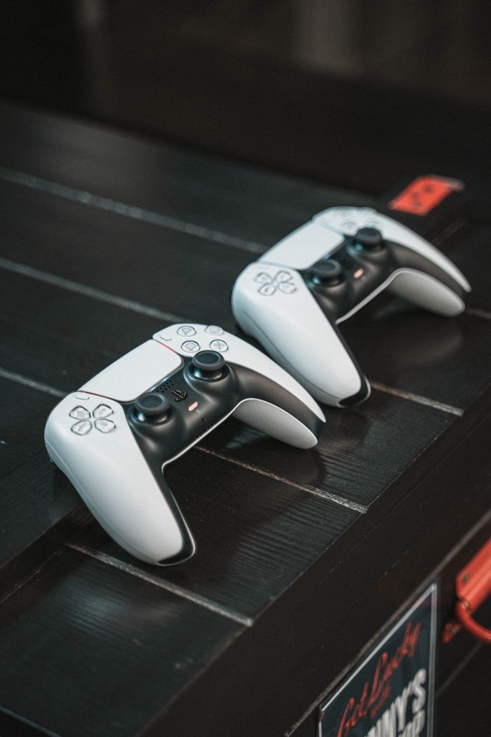 Two white gaming controllers on a black table, perfect for tech or gaming content.